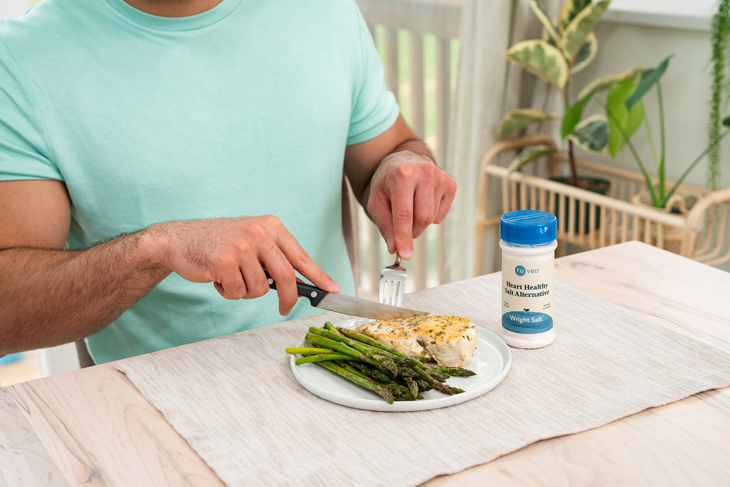A person cutting food with Wright Salt next to them.