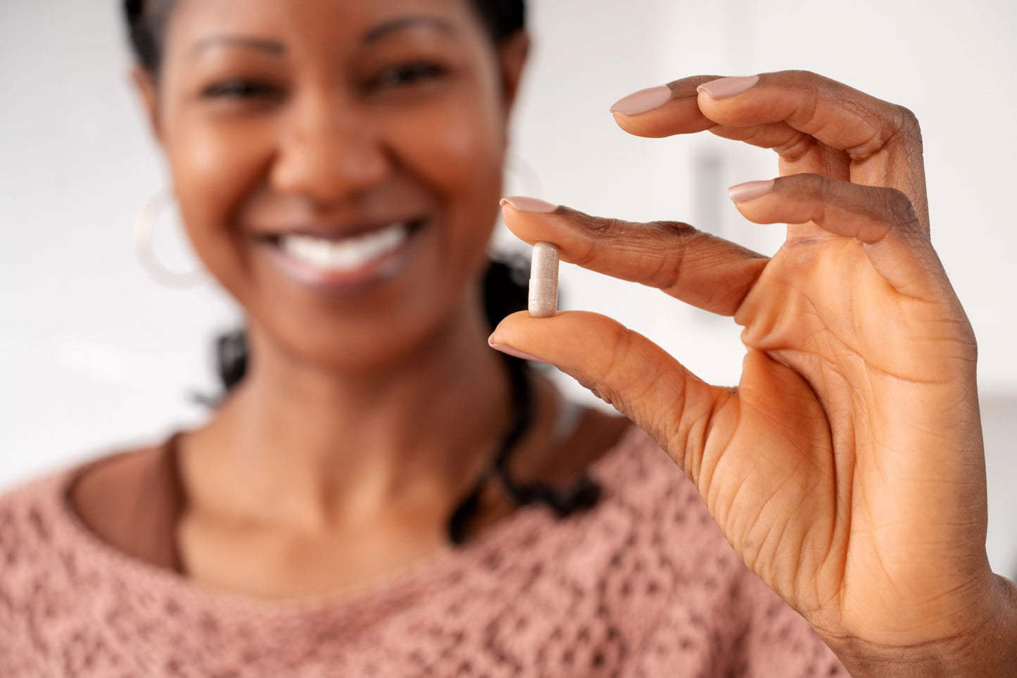 A happy woman holding a Guggul Power capsule