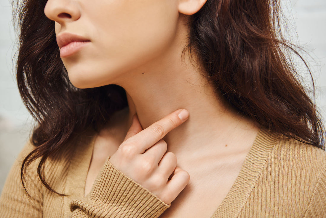 A woman massaging her neck near the lymphatic system. 