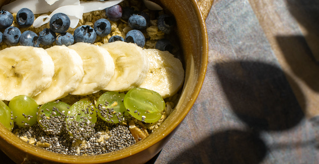 Fruits, seeds, and granola inside of a bowl.