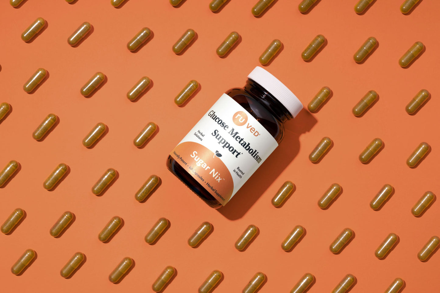 A bottle of Sugar Nix sitting on an orange background around a bunch of capsules. 